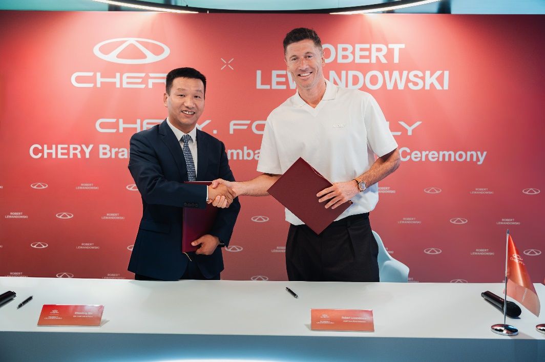 Handschlag zwischen Robert Lewandowski und einem Vertreter von CHERY bei der Signing Ceremony