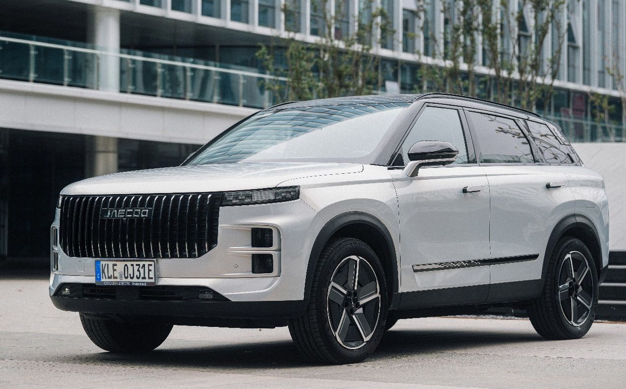Weißer JAECOO 7 PHEV in der Seitenansicht vor einem Gebäude